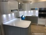 Белая п-образная кухонная столешница из агломерата кварца с бортиком фото